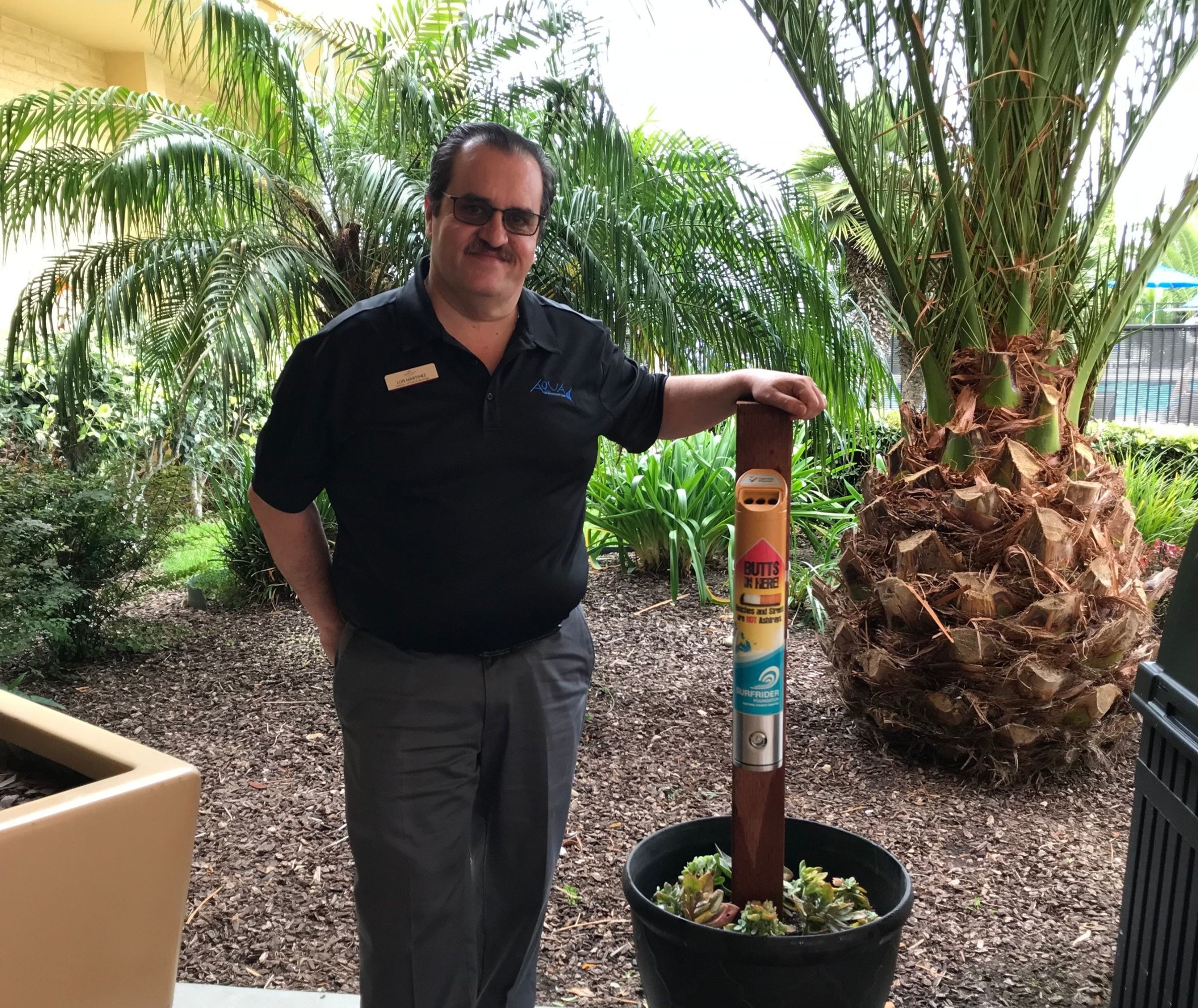 A man standing in front of a HOTYB ashcan. 