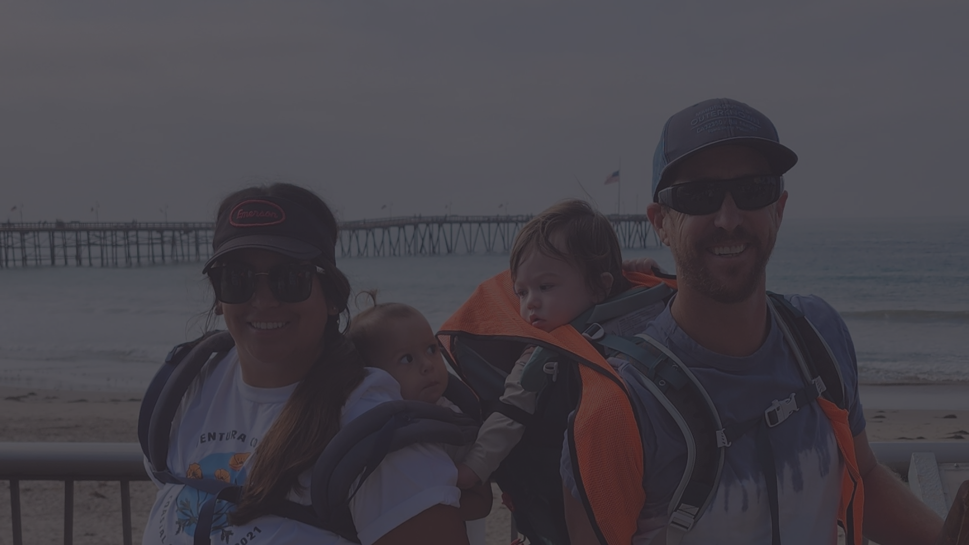 Volunteers and their babies posing for a photo at a beach cleanup.